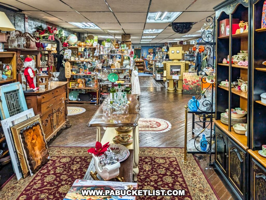 Interior view of Duchess Outlet Antiques in Pittston, PA, showing vendor booths filled with vintage furniture, glassware, artwork, collectibles, and decorative items arranged throughout the spacious store.