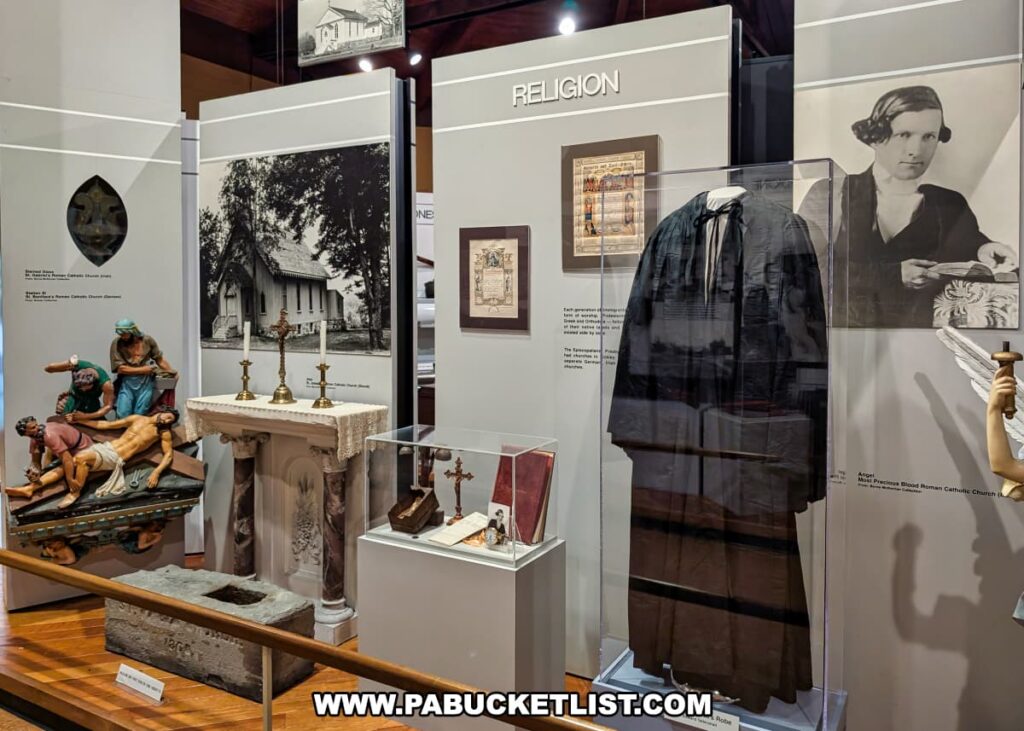 Religion exhibit inside the Eckley Miners’ Village Museum in Luzerne County, Pennsylvania, featuring a priest’s robe, church altar items, religious statues, historic photographs, and artifacts reflecting the role of faith in coal mining communities.