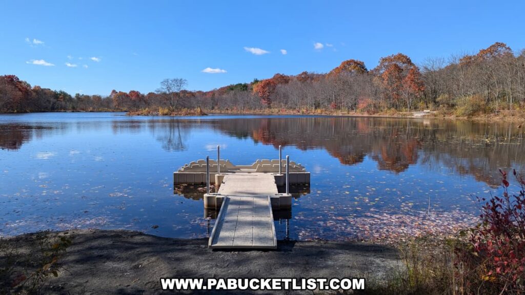 Boat launch at Lake Frances in Nescopeck State Park, surrounded by calm blue water and vibrant autumn foliage reflecting on the lake’s surface.