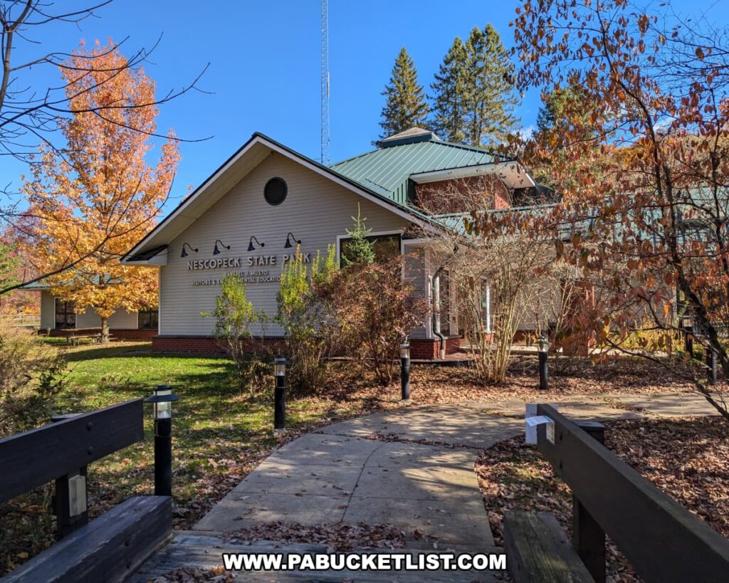 Nescopeck State Park visitor center in Luzerne County surrounded by colorful autumn trees, with a paved walkway leading to the entrance.