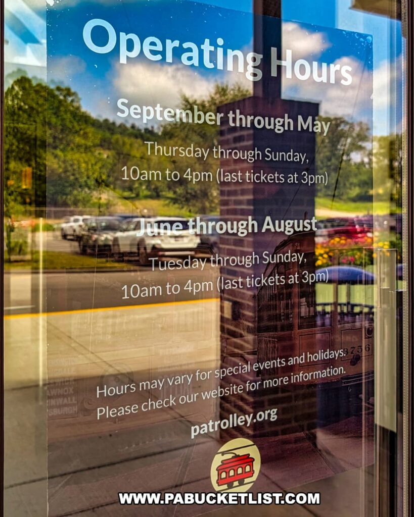 Operating hours sign on the entrance door of the Pennsylvania Trolley Museum in Washington County, Pennsylvania, listing seasonal schedules from September through May and June through August, with museum hours from 10 am to 4 pm and last tickets sold at 3 pm.