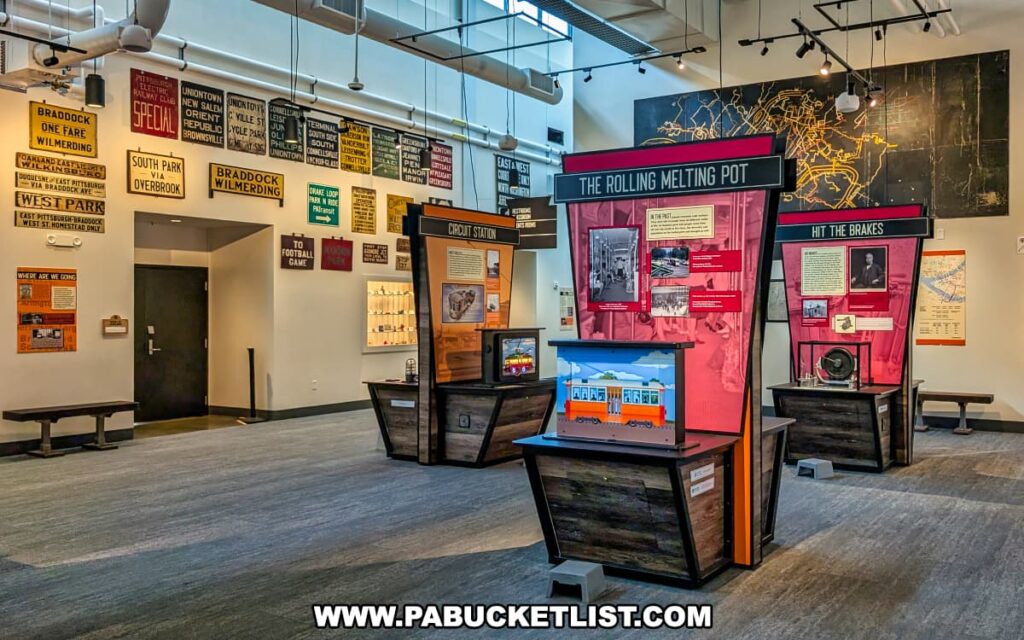 Exhibit area inside the Pennsylvania Trolley Museum in Washington County, Pennsylvania, featuring colorful displays about trolley history, vintage transit signs mounted on the wall, and interactive educational panels for visitors.