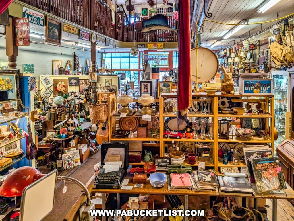 First-floor view inside Wexford General Store Antiques in Allegheny County, PA, showcasing shelves and displays filled with vintage collectibles, records, glassware, musical instruments, and décor beneath a balcony lined with additional booths and antique signage.