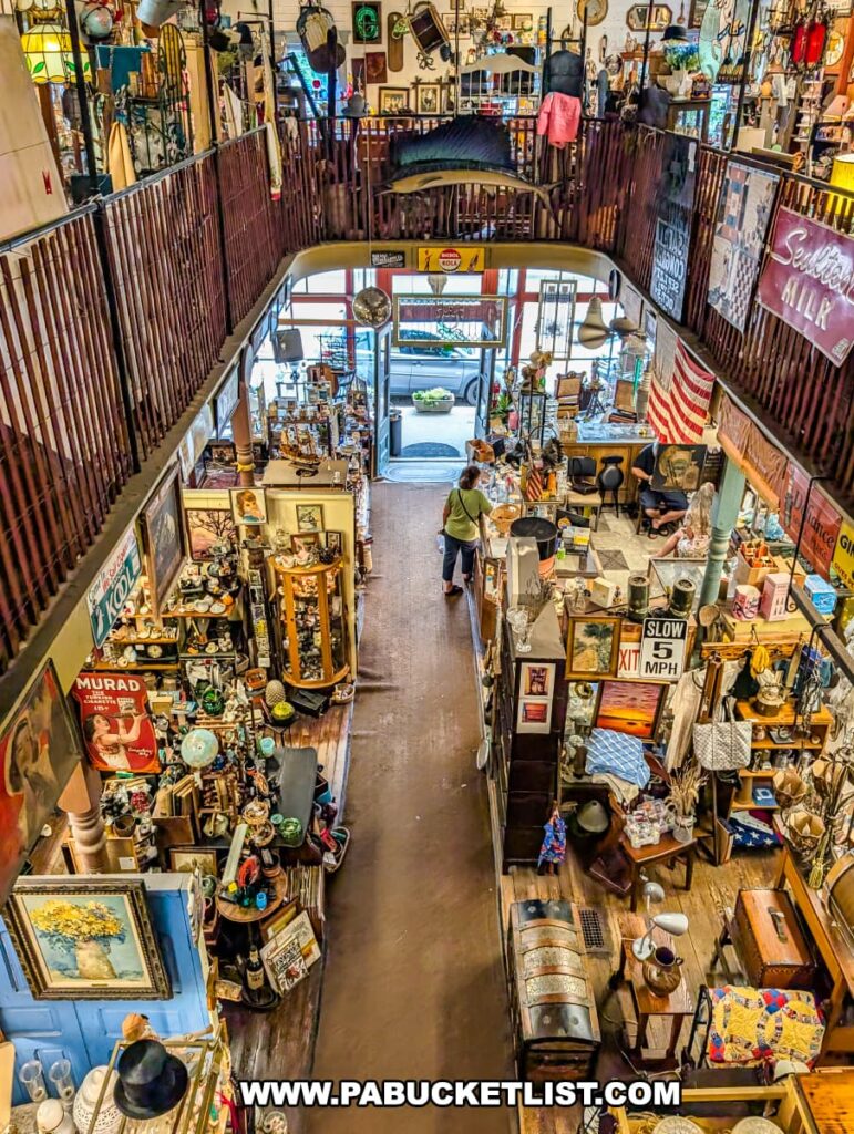 View from the second floor of Wexford General Store Antiques in Allegheny County, PA overlooking the main entrance and first-floor vendor booths filled with vintage furniture, signs, collectibles, and decorative antiques.