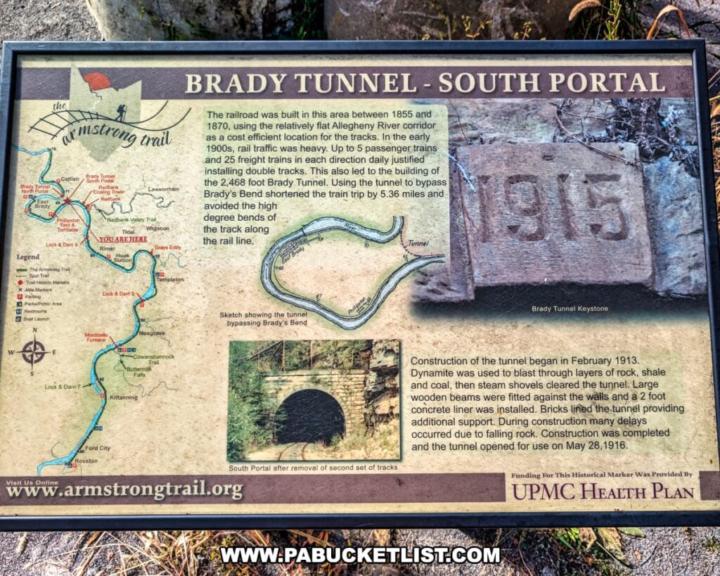 Informational sign along the Armstrong Trail in western Pennsylvania describing the history and construction of the Brady Tunnel, including a map of the trail, a sketch of how the tunnel bypassed Brady’s Bend, and historic photos of the tunnel and keystone marked 1915.
