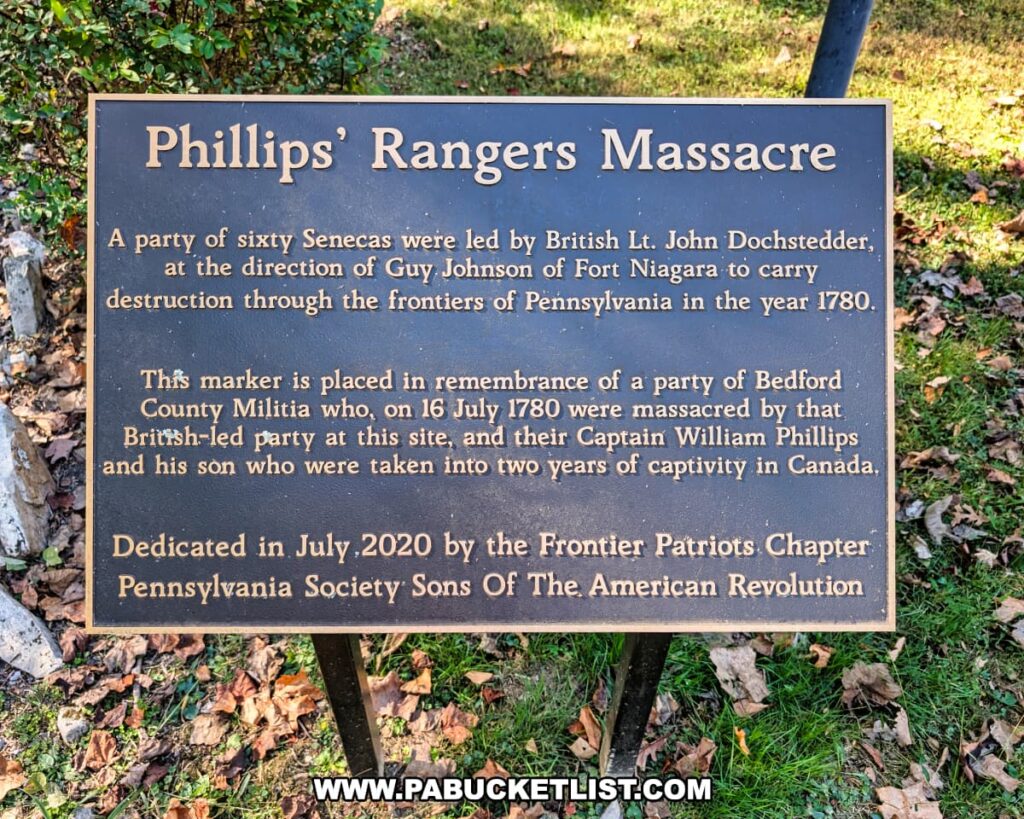 Informational plaque at the Captain Phillips’ Rangers Memorial in Bedford County, Pennsylvania, describing the July 16, 1780 massacre of Captain William Phillips’ Bedford County Militia by a British-led Seneca war party and noting the monument’s 2020 dedication by the Frontier Patriots Chapter of the Sons of the American Revolution.