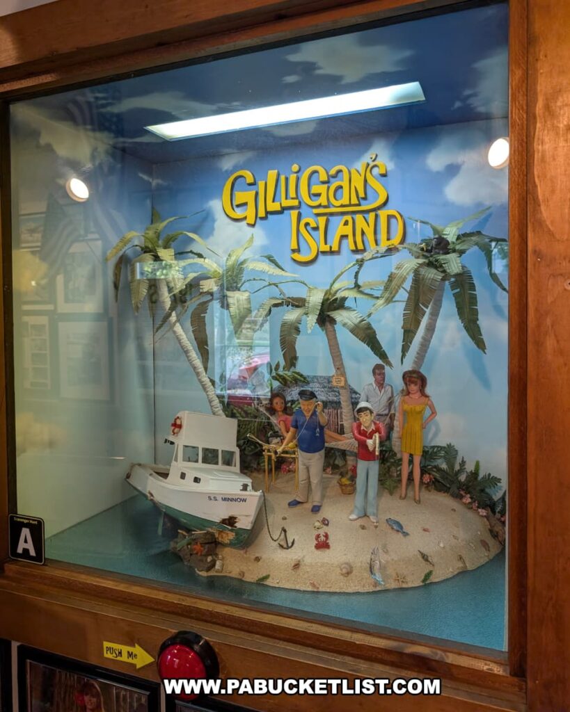 A display at Cooper’s Seafood House in Scranton, Pennsylvania, featuring a detailed *Gilligan’s Island* diorama with miniature characters, palm trees, and the S.S. Minnow boat on a sandy island beneath the show’s logo.