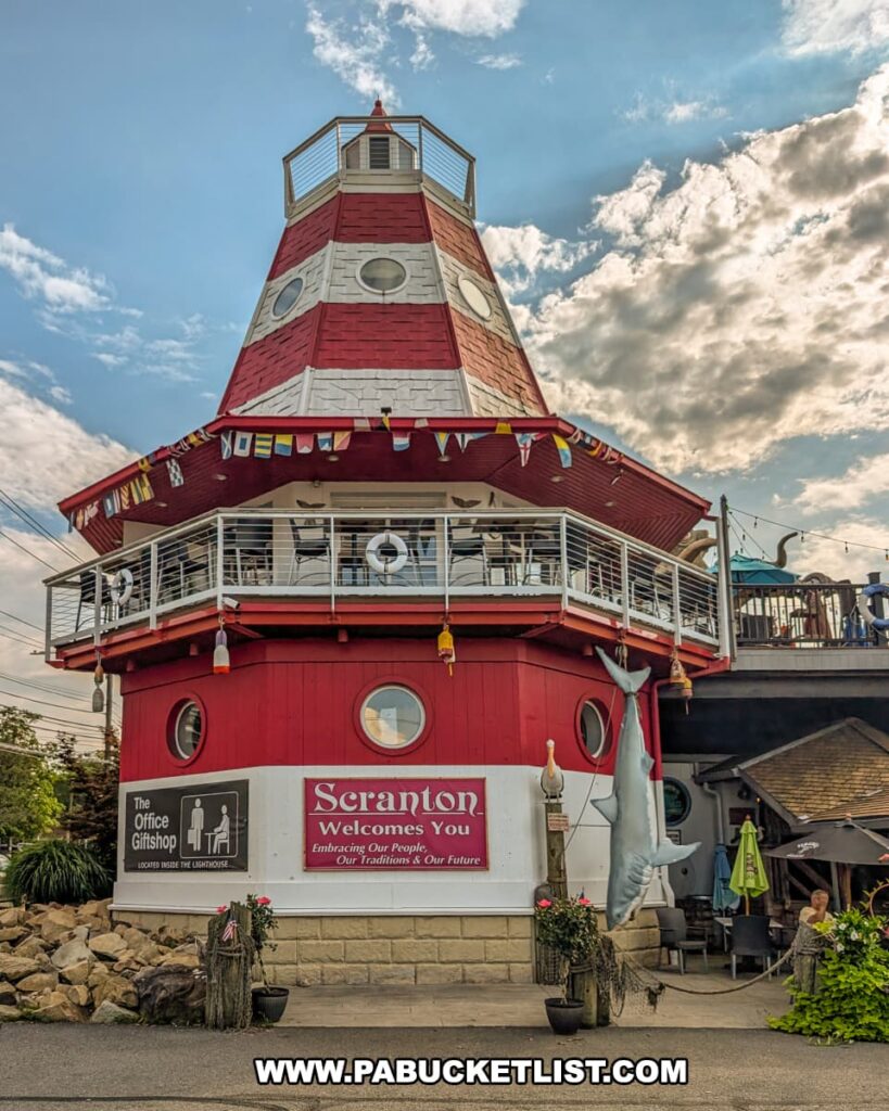 The red-and-white lighthouse tower at Cooper’s Seafood House in Scranton, Pennsylvania, decorated with nautical flags and a hanging shark, housing “The Office” gift shop and serving as a landmark feature of the restaurant’s whimsical seaside-themed exterior.