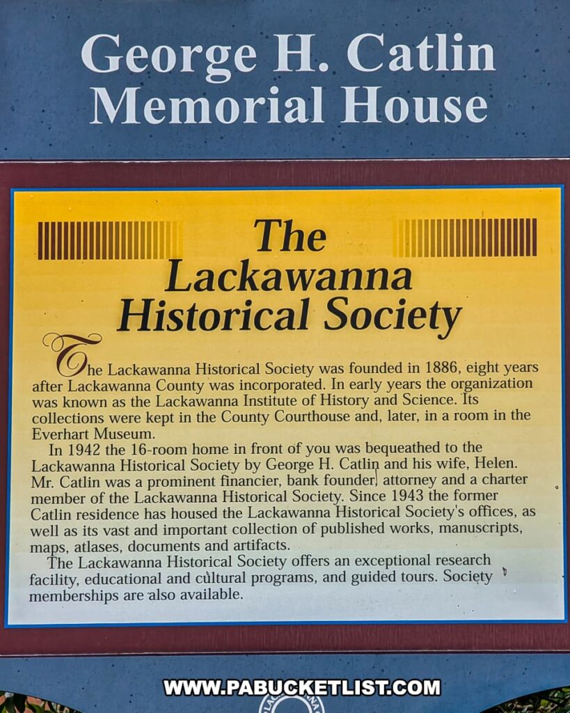 Informational sign at the George H. Catlin Memorial House in Scranton, Pennsylvania, describing the history of the Lackawanna Historical Society. The sign explains that the society was founded in 1886, originally known as the Lackawanna Institute of History and Science, and that the Catlin House was bequeathed to the society in 1942 by George and Helen Catlin. It highlights the home’s role since 1943 as the society’s headquarters and research center, preserving manuscripts, maps, documents, and artifacts related to Scranton and Lackawanna County history.