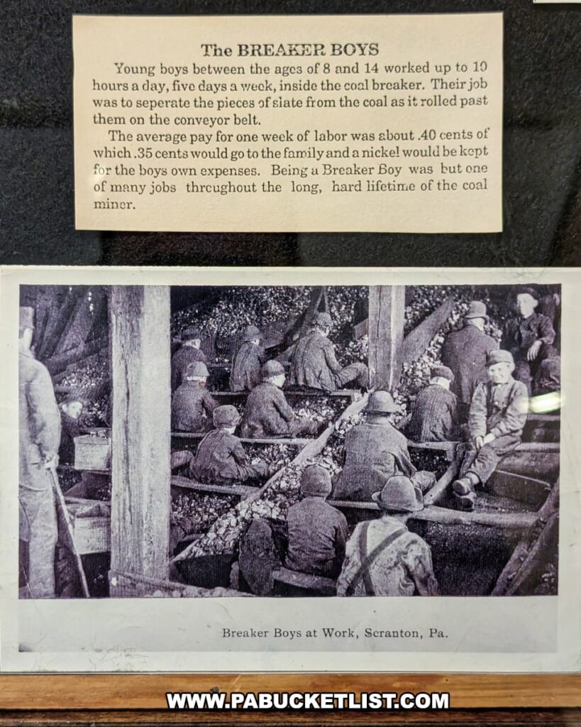 Exhibit at the Lackawanna Historical Society Museum in Scranton, Pennsylvania, featuring a historical display about the “Breaker Boys.” The exhibit includes a vintage photograph labeled “Breaker Boys at Work, Scranton, Pa.” showing young boys sorting coal in a breaker, along with a descriptive panel explaining their harsh working conditions, long hours, and meager pay during the early coal mining era in northeastern Pennsylvania.