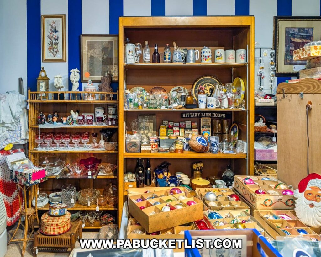 Colorful display of vintage glassware, holiday ornaments, collectibles, and Penn State–themed memorabilia arranged on shelves and tables at Apple Hill Antiques near State College.