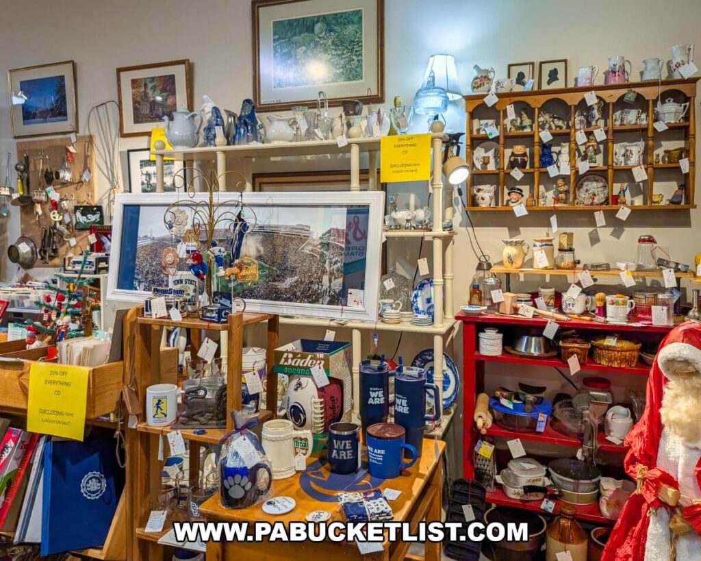 Display area at Apple Hill Antiques near State College featuring Penn State memorabilia, vintage kitchenware, decorative ceramics, framed artwork, and assorted collectibles arranged on shelves and tables.