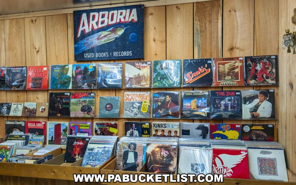 Wall display of vintage vinyl records at Apple Hill Antiques near State College, arranged beneath a retro “Arboria Used Books & Records” sign on a rustic wood-paneled wall.