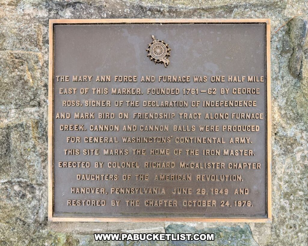Close-up view of a bronze historical plaque at Codorus State Park in York County, Pennsylvania, commemorating the Mary Ann Forge and Furnace, which produced cannon and cannonballs for General Washington’s Continental Army during the Revolutionary War.