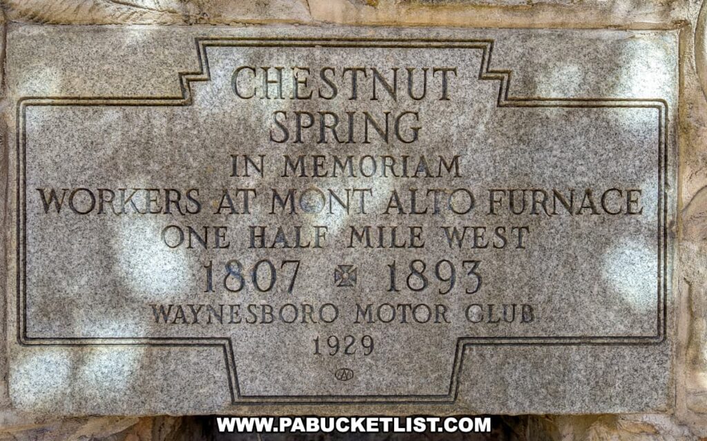 Close-up of the Chestnut Spring monument plaque at Mont Alto State Park in Franklin County, Pennsylvania, inscribed in memory of the Mont Alto Furnace workers from 1807 to 1893 and dedicated by the Waynesboro Motor Club in 1929.