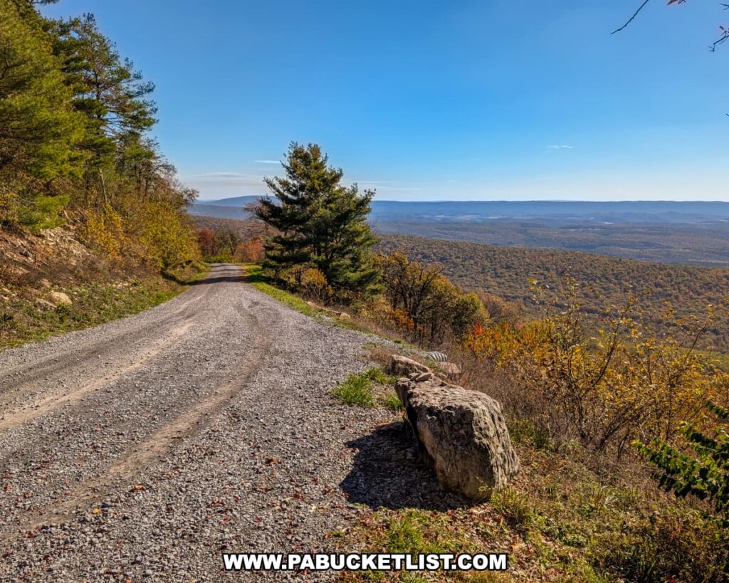 Scenic gravel pull-off at Harry’s Valley Vista in Rothrock State Forest, offering sweeping views of rolling forested ridges and distant mountain ranges under a clear blue autumn sky.