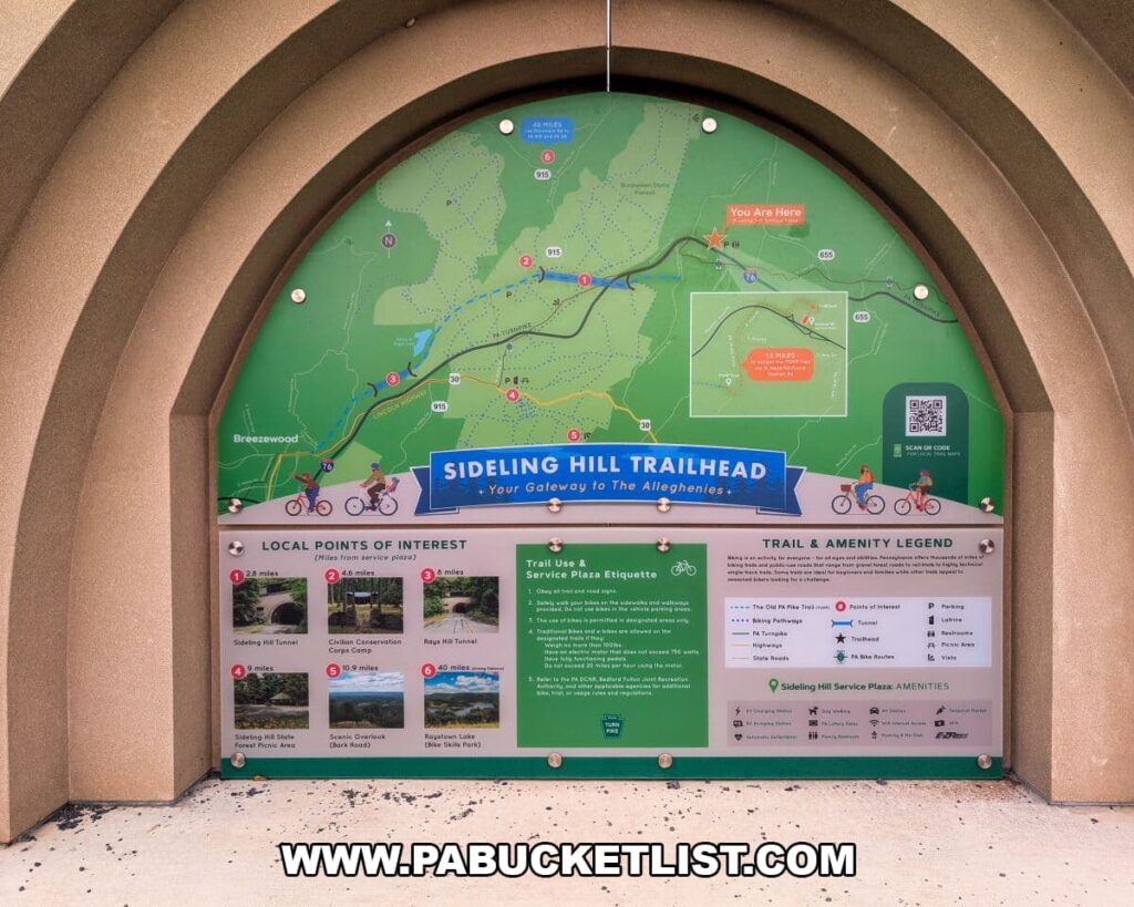 Informational kiosk at the Sideling Hill Trailhead displaying a detailed map, trail guidelines, and nearby points of interest for visitors accessing the Abandoned PA Turnpike, an 8.5-mile former highway stretch running through Bedford and Fulton counties.
