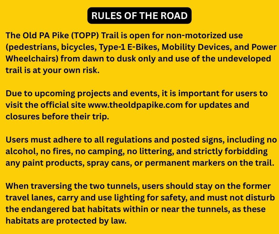 Yellow “Rules of the Road” sign for the Old PA Pike (TOPP) Trail, outlining safety guidelines, permitted uses, prohibited activities, and bat-habitat protections for visitors exploring the 8.5-mile Abandoned PA Turnpike in Bedford and Fulton counties.