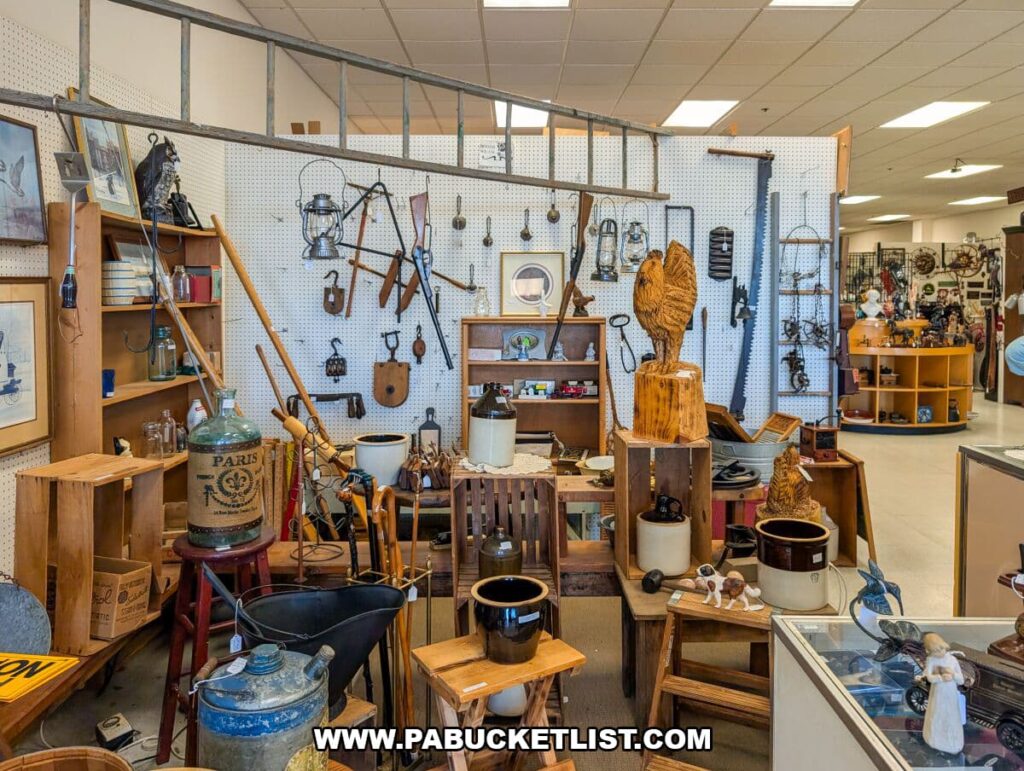 Farmhouse-style vendor booth at Black Rose Antiques in Hanover, Pennsylvania, displaying rustic décor such as stoneware crocks, wooden crates, lanterns, hand tools, carved wooden roosters, enamelware, and vintage household items arranged against a pegboard wall.