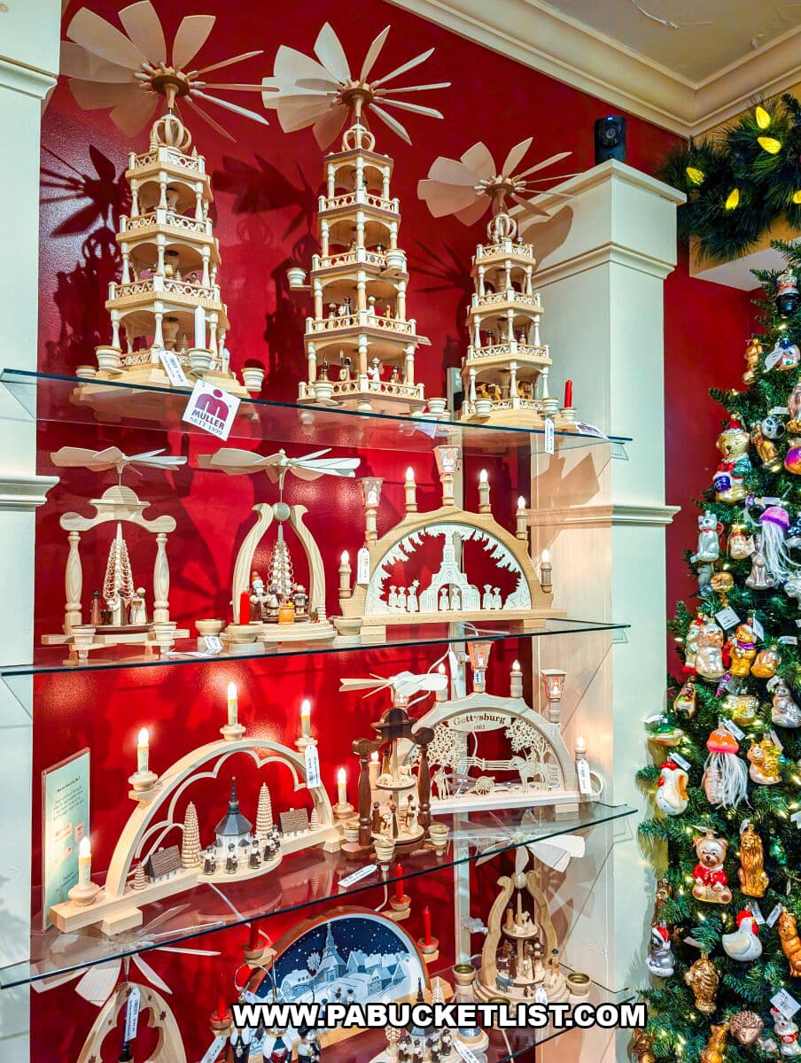 Display shelves at The Christmas Haus in Gettysburg filled with handcrafted German Christmas pyramids, wooden candle arches, figurines, and ornaments beside a decorated Christmas tree.