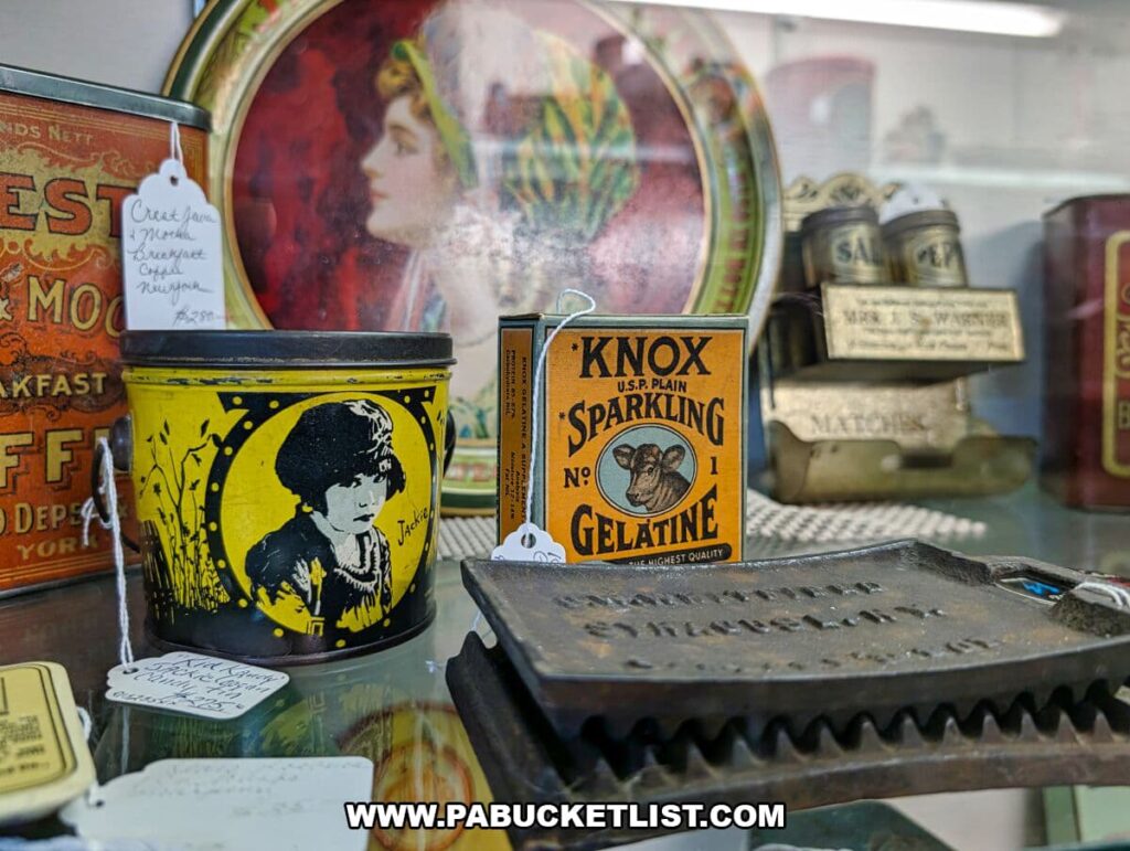 Close-up of vintage advertising tins and food product containers at Collector’s Choice Antiques Gallery in New Oxford, Pennsylvania, including a Knox Gelatine box, a yellow Jackie Coogan tin, and other early 20th-century packaging on display.