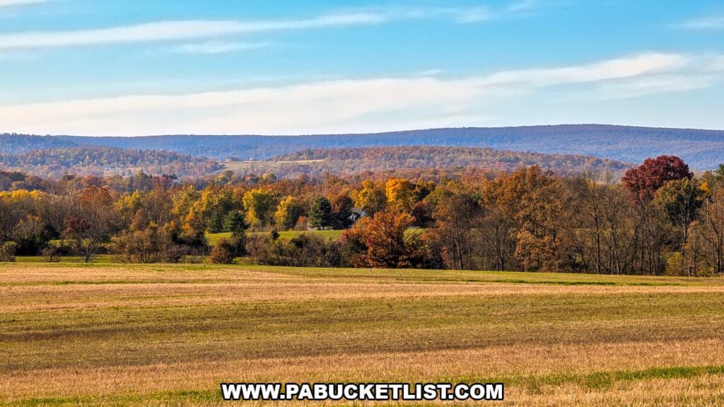 Rolling farmland at the Eisenhower farm in Gettysburg with autumn foliage and a distant view of South Mountain under a blue sky.