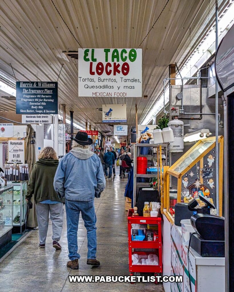 Shoppers walking down a busy indoor aisle at Morning Sun Marketplace in York County, PA, passing food and retail vendors including a Mexican eatery with a hanging sign reading “El Taco Loco.”