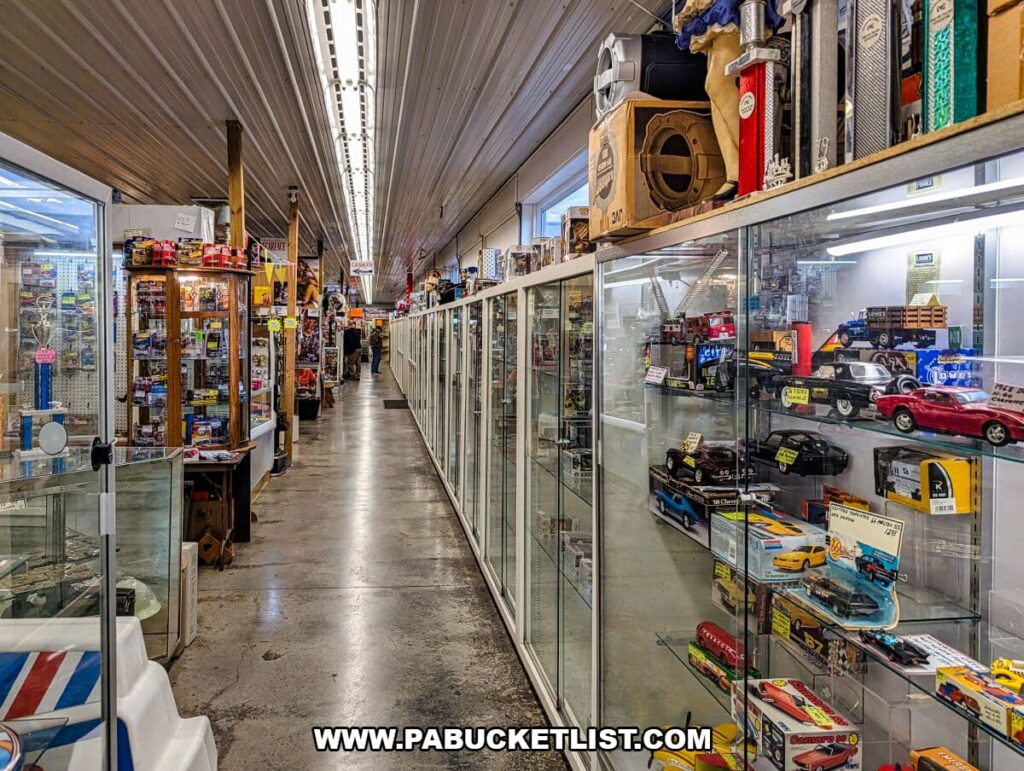 A long indoor aisle at Morning Sun Marketplace in York County, PA, with glass display cases filled with collectible toy cars and shelves of vintage items and memorabilia lining the walkway.
