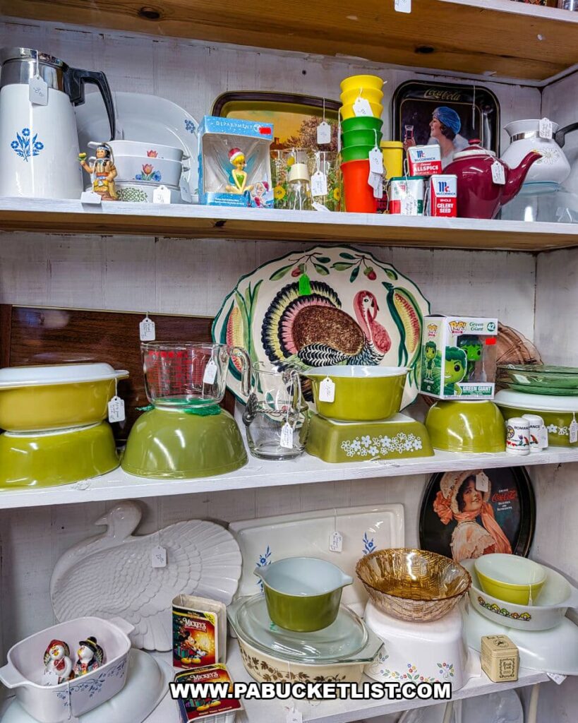 Shelves of vintage kitchenware at Morning Sun Marketplace in York County, PA, featuring colorful mixing bowls, Pyrex dishes, glassware, spice tins, figurines, and retro serving trays.
