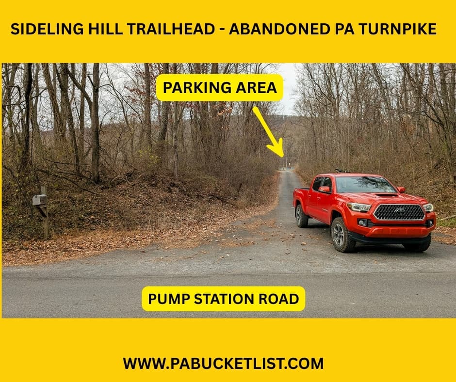 Photo showing the approach to the Sideling Hill Trailhead from Pump Station Road, with a red pickup truck parked at the intersection and an arrow indicating the parking area located up the narrow, tree-lined access road leading to the 8.5-mile Abandoned PA Turnpike in Bedford and Fulton counties.