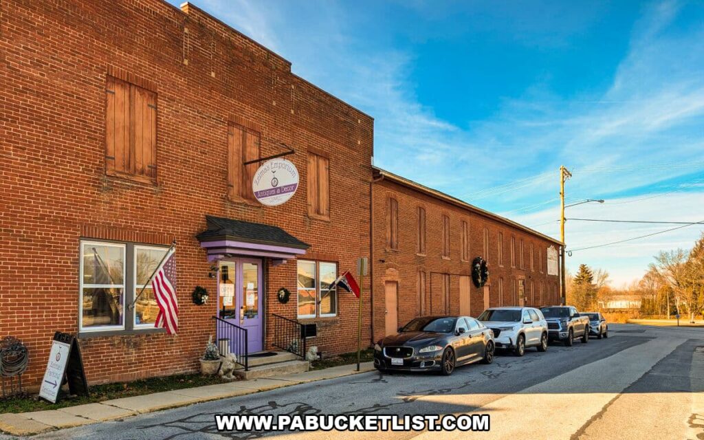 Exterior view of Zelma’s Emporium, a two-story brick antique mall in Adams County, Pennsylvania, featuring a purple front entrance, American flags, holiday wreaths, and parked cars along the street.