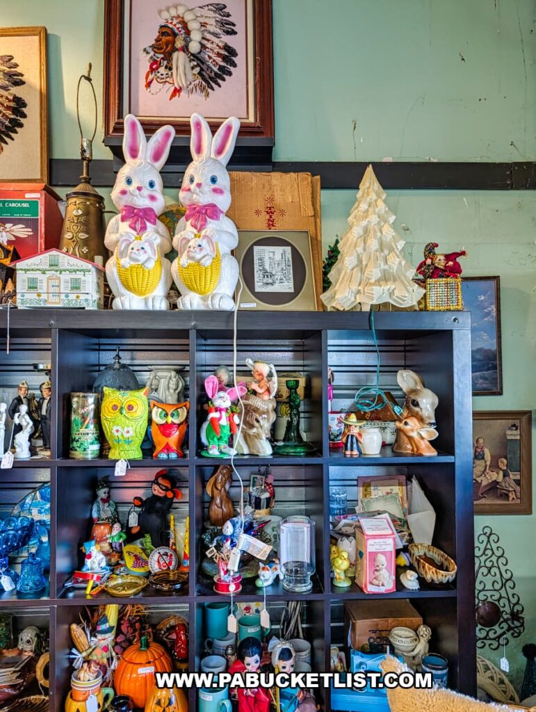 Shelving inside American Daydream Antiques in York County, Pennsylvania, filled with vintage holiday decor including lighted Easter bunny figures, ceramic Christmas trees, figurines, seasonal glassware, and assorted retro collectibles in a multi-vendor antique store