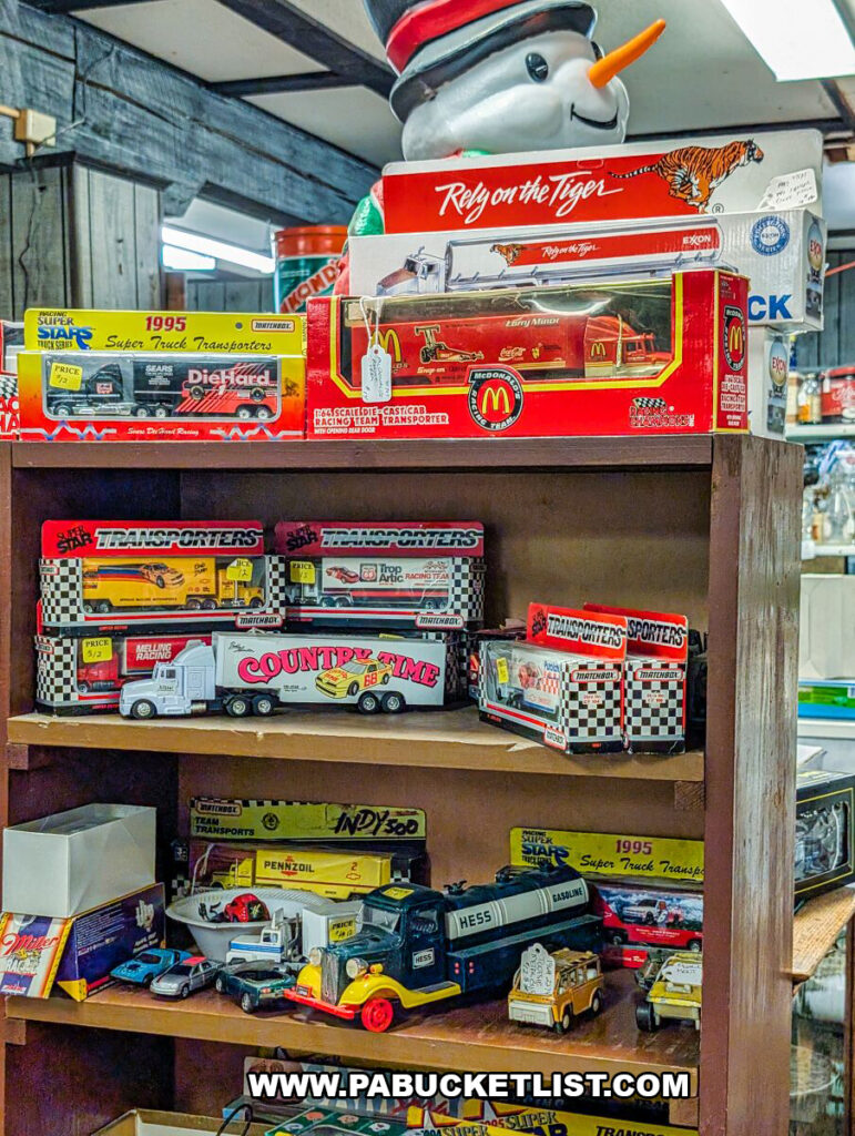 A wooden shelving unit at Black Shutter Antiques in New Oxford, Pennsylvania, displaying vintage toy trucks, NASCAR transporters, Matchbox vehicles, and collectible advertising items inside the multi-vendor antique store