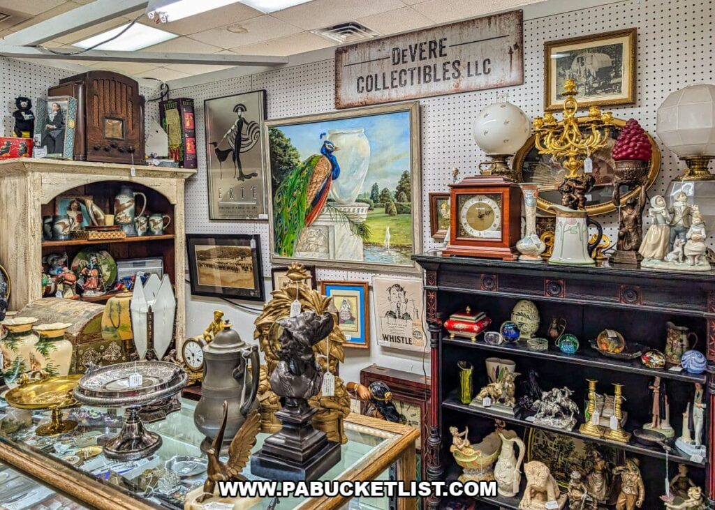 Curated vendor booth at Crossroads Antique Mall in Hershey, Pennsylvania, showcasing antique lamps, statuary, clocks, framed artwork, decorative glass, figurines, and vintage collectibles arranged against pegboard walls inside the historic barn.