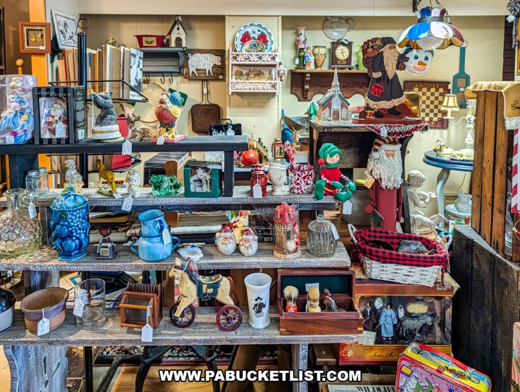 Interior view of a vendor booth at Dover Antique Mall in York County, Pennsylvania, featuring layered shelves filled with vintage glassware, figurines, holiday décor, small wooden toys, books, and assorted household collectibles arranged in a cozy, eclectic display.