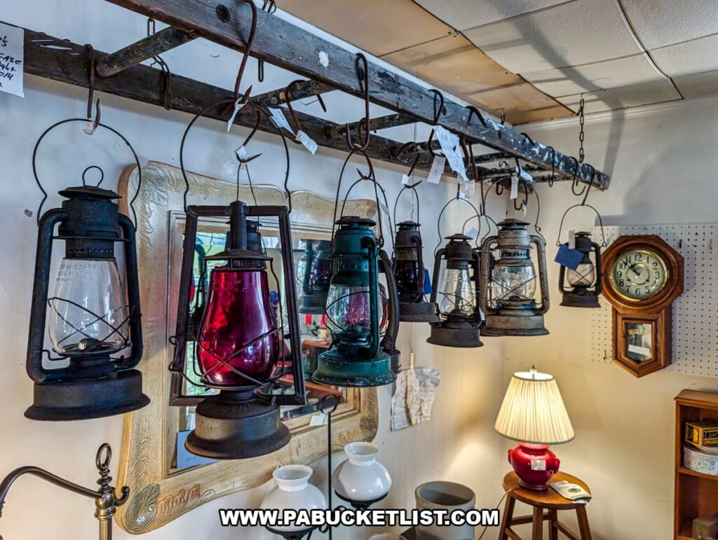 Row of vintage kerosene lanterns hanging from a rustic wooden beam at Grey Beards Antiques in York County, Pennsylvania, featuring assorted metal frames and colored glass globes displayed inside the multi-vendor antique mall in Jacobus.