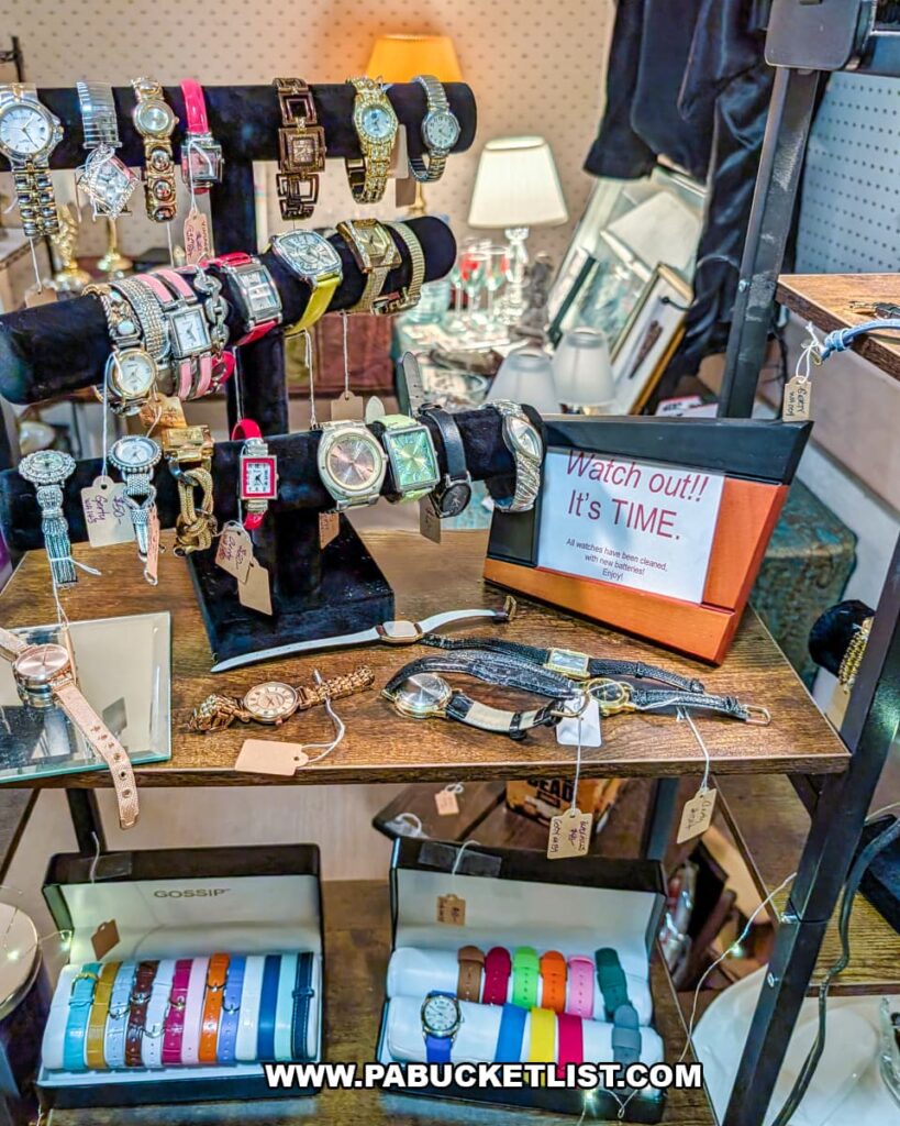 Assortment of vintage wristwatches displayed on velvet stands and shelves at Grey Beards Antiques in York County, Pennsylvania, featuring metal and leather bands, colorful straps, and timepieces arranged within a vendor booth at the multi-vendor antique mall in Jacobus.