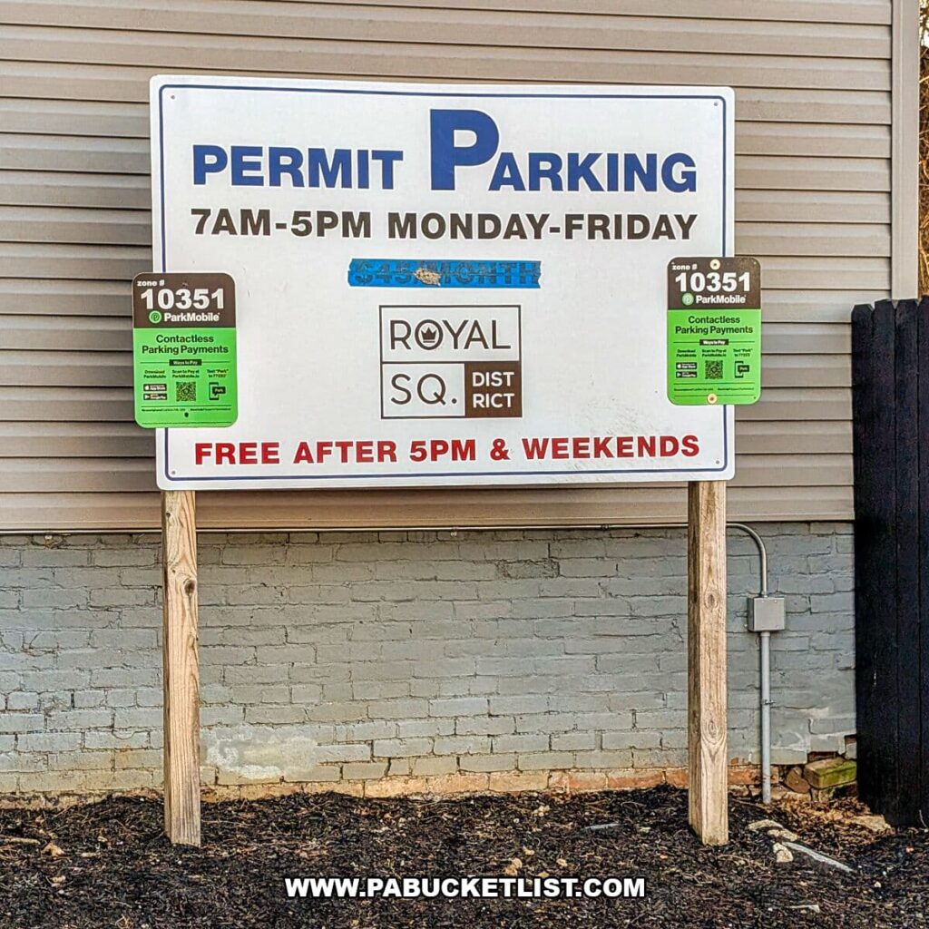 Parking information sign in the Royal Square District of downtown York, Pennsylvania, indicating permit parking from 7 a.m. to 5 p.m. Monday through Friday, with free parking after 5 p.m. and on weekends, posted near Royal Square Mural Park.