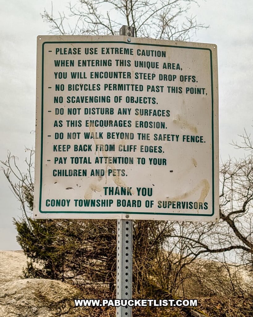 Posted safety sign from Conoy Township listing rules and warnings about steep drop-offs, erosion, and cliff edges at the White Cliffs of Conoy in Lancaster County, Pennsylvania.