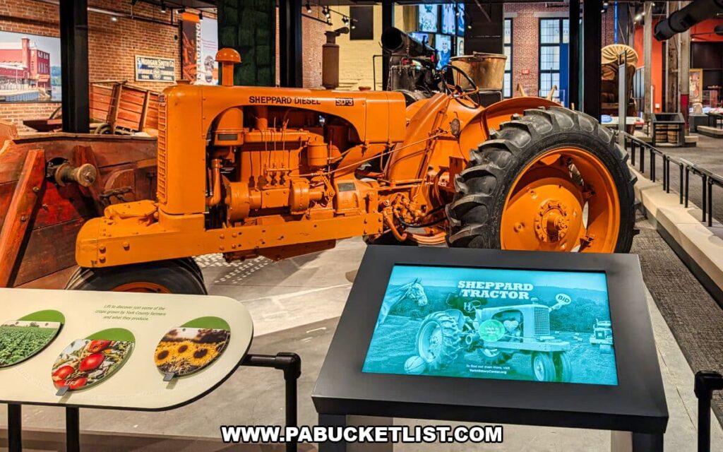 Sheppard tractor exhibit at the York County History Center featuring a bright orange vintage Sheppard diesel tractor alongside interactive displays explaining York County’s agricultural and manufacturing heritage.
