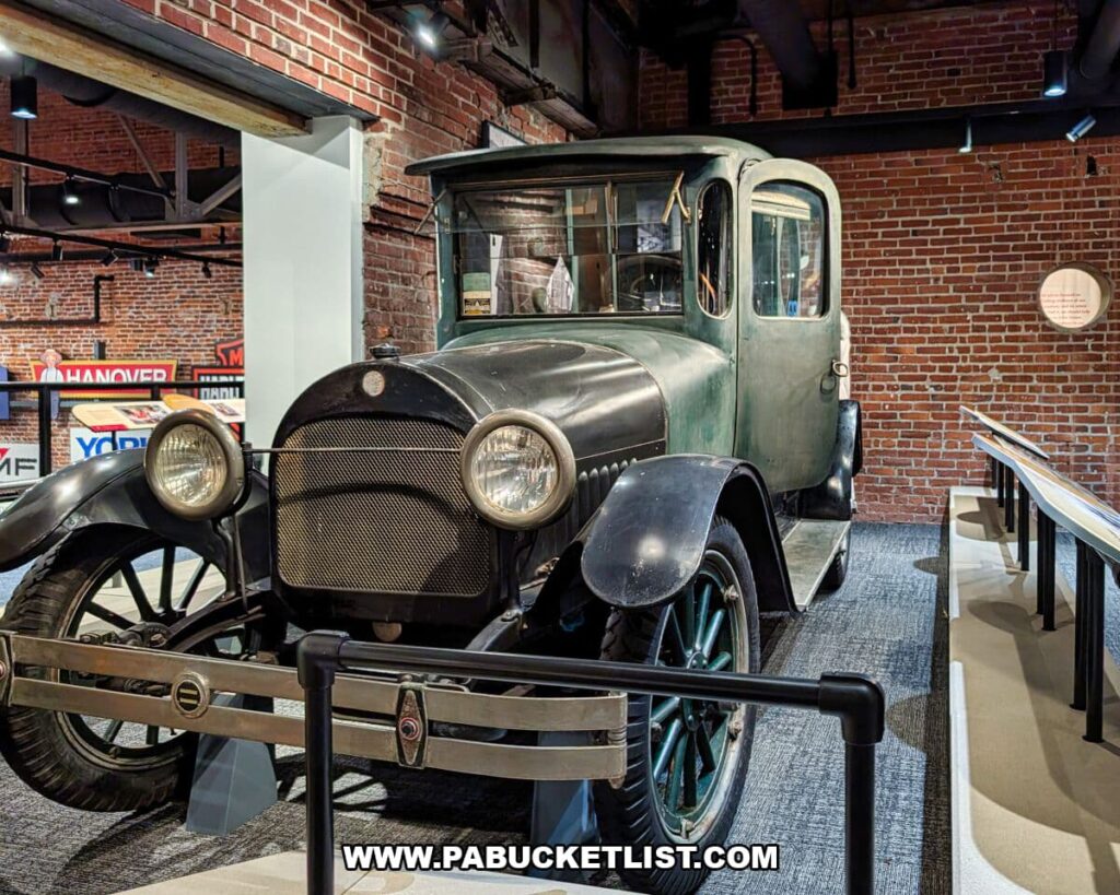 Early 20th-century antique automobile on display inside the York County History Center, shown against exposed brick walls as part of an exhibit exploring the region’s transportation and industrial history.