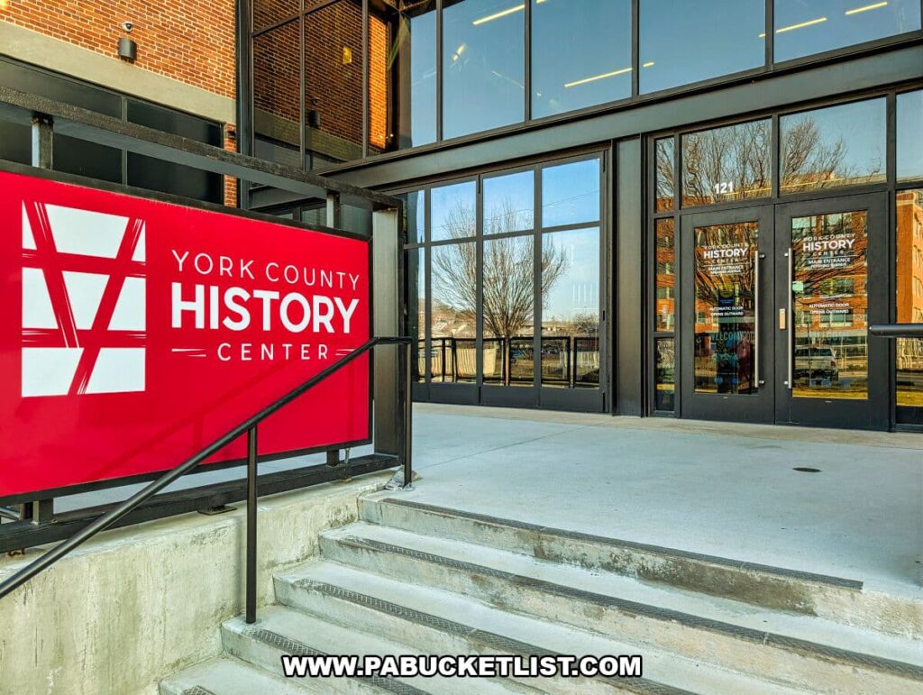 Exterior entrance of the York County History Center in York, Pennsylvania, featuring a bold red museum sign and glass doors welcoming visitors into the historic former power plant building.