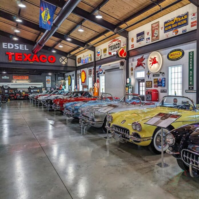 Row of classic Chevrolet Corvettes on display inside Barry’s Car Barn in Lancaster County, Pennsylvania, surrounded by vintage Texaco, Mobil, and Goodyear automotive signs in a spacious showroom.
