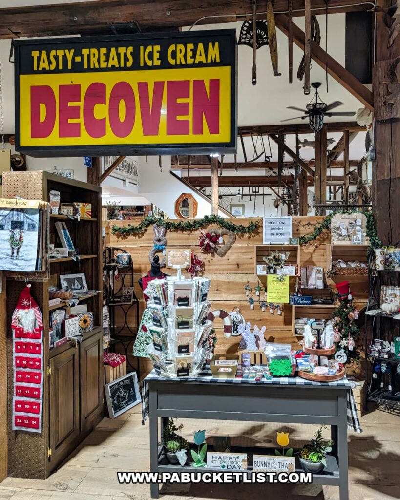Display area inside Cove Barn Antiques in Duncannon, Pennsylvania, featuring handmade crafts, greeting cards, seasonal decor, and vintage signage beneath exposed wooden barn beams