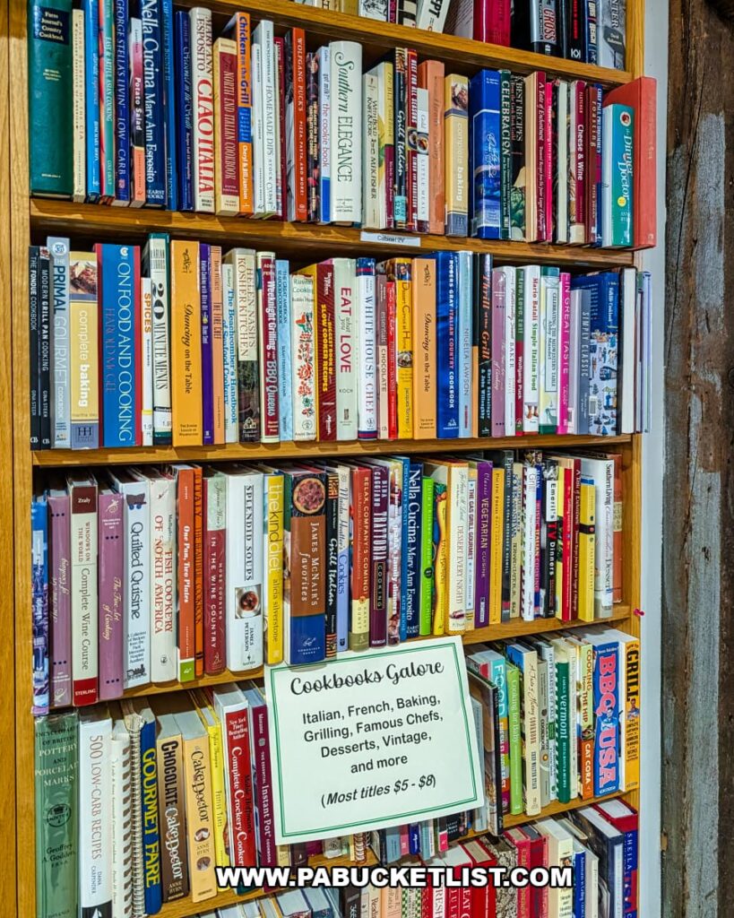 Bookshelf inside Cove Barn Antiques in Duncannon, Pennsylvania, filled with rows of vintage cookbooks on topics like baking, grilling, international cuisine, and classic recipes