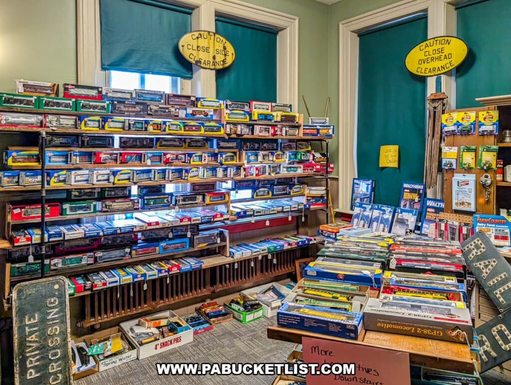 Display of vintage model trains and railroad accessories inside Sunbury Station Antiques in Northumberland County, Pennsylvania, featuring shelves of boxed locomotives and railcars beneath tall arched windows in the historic train station building.