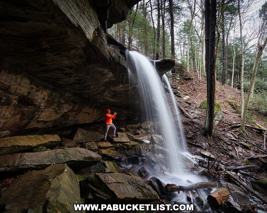 Photographer standing beneath the rock overhang beside Kildoo Falls at McConnells Mill State Park in Lawrence County, Pennsylvania.