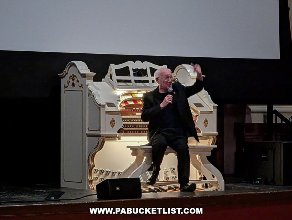 Presenter speaking beside the historic Mighty Wurlitzer theater organ on stage at the Capitol Theatre in the Appell Center for the Performing Arts in York, Pennsylvania.