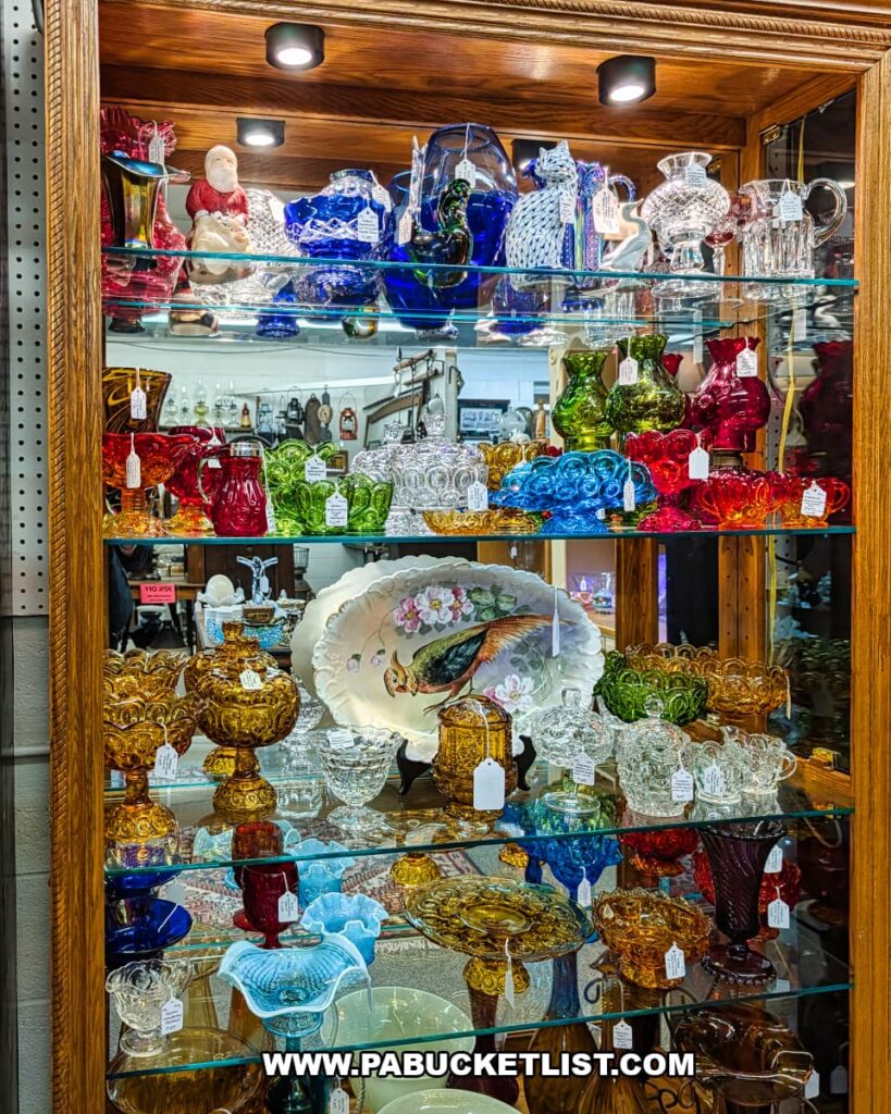 Glass display case filled with colorful vintage glassware, bowls, and decorative pieces at Fayetteville Antique & Craft Mall in Franklin County, Pennsylvania.