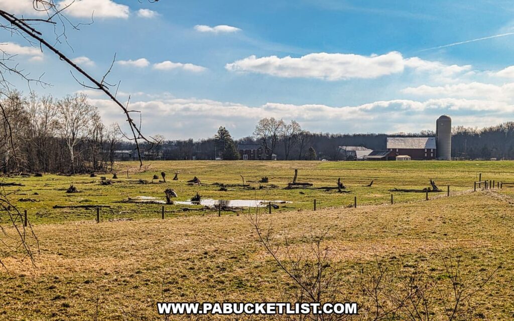 Open farm fields with tree stumps, a barn, and silo on the Gettysburg Battlefield landscape viewed from a Gettysburg Railway sightseeing train excursion in Gettysburg, Pennsylvania.